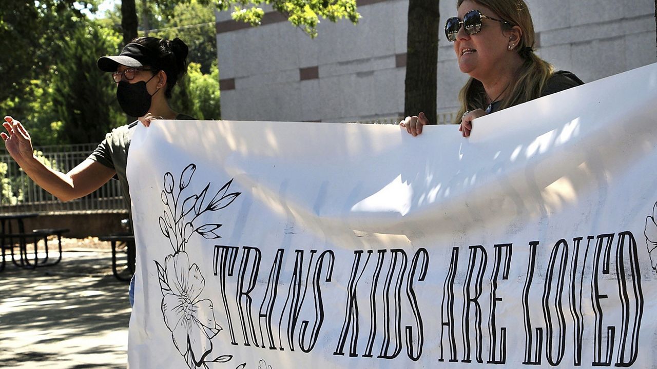 Heather Redding, left, and Elizabeth Waugh, of Orange County, N.C., rally for transgender rights outside the state Legislative Building, Aug. 16, 2023, in Raleigh, N.C. (AP Photo/Hannah Schoenbaum)