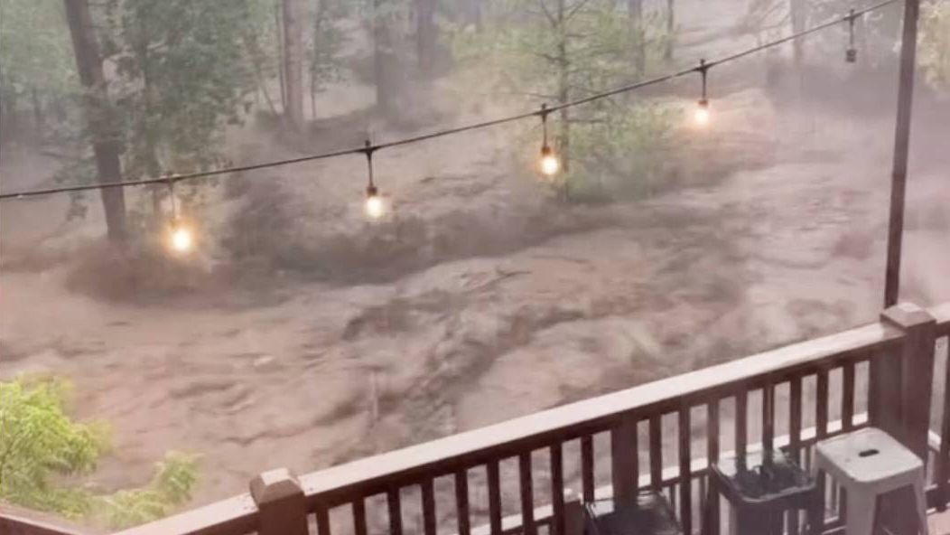 In this image taken from video, flash flooding is seen behind a house in Ruidoso, N.M., Tuesday, July 8, 2025. (Kaitlyn Carpenter via AP)