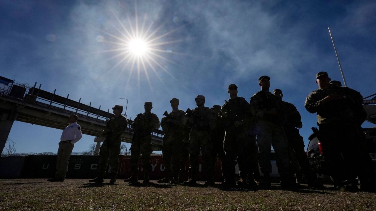 Members of the National Guard stand as Texas Gov. Greg Abbott and fellow governors hold a news conference along the Rio Grande to discuss Operation Lone Star and border concerns, Feb. 4, 2024, in Eagle Pass, Texas. (AP Photo/Eric Gay, file)
