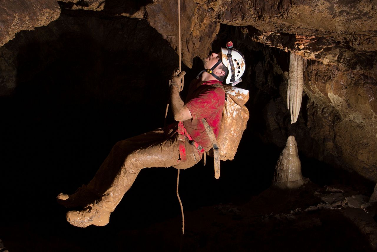 A cave diver descending the wall of the 600 ft. cave.