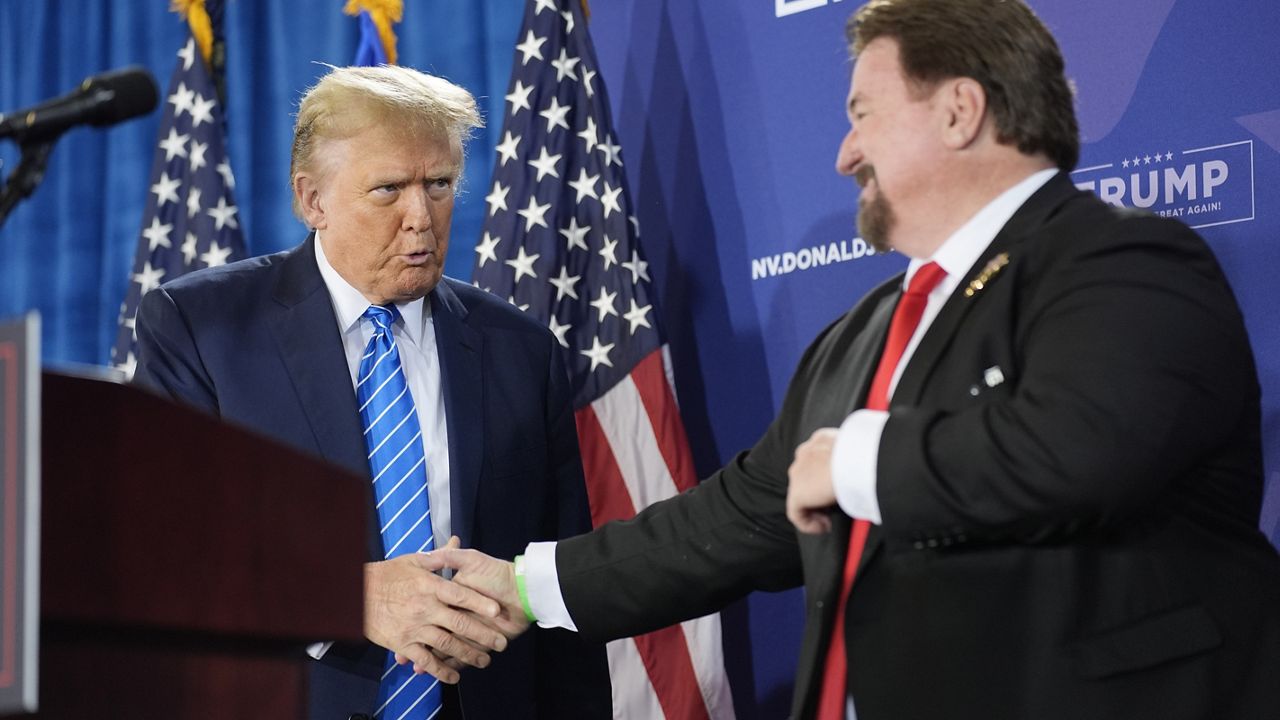 FILE - Nevada GOP chair Michael McDonald, right, shakes hands with Republican presidential candidate former President Donald Trump at a campaign event, Jan. 27, 2024, in Las Vegas. Six Republicans accused of falsely declaring Donald Trump the winner of Nevada’s 2020 presidential election will not stand trial until sometime next year. A Nevada judge on Monday, March 4, 2024 pushed back the trial date due to conflicting schedules. The judge also set an April 22 hearing on a bid by McDonald and other defendants to throw out the indictment. (AP Photo/John Locher, File)