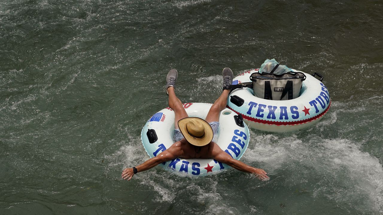 A tuber floats the cool waters of the Comal River, Tuesday, June 14, 2022, in New Braunfels, Texas. (AP Photo/Eric Gay)