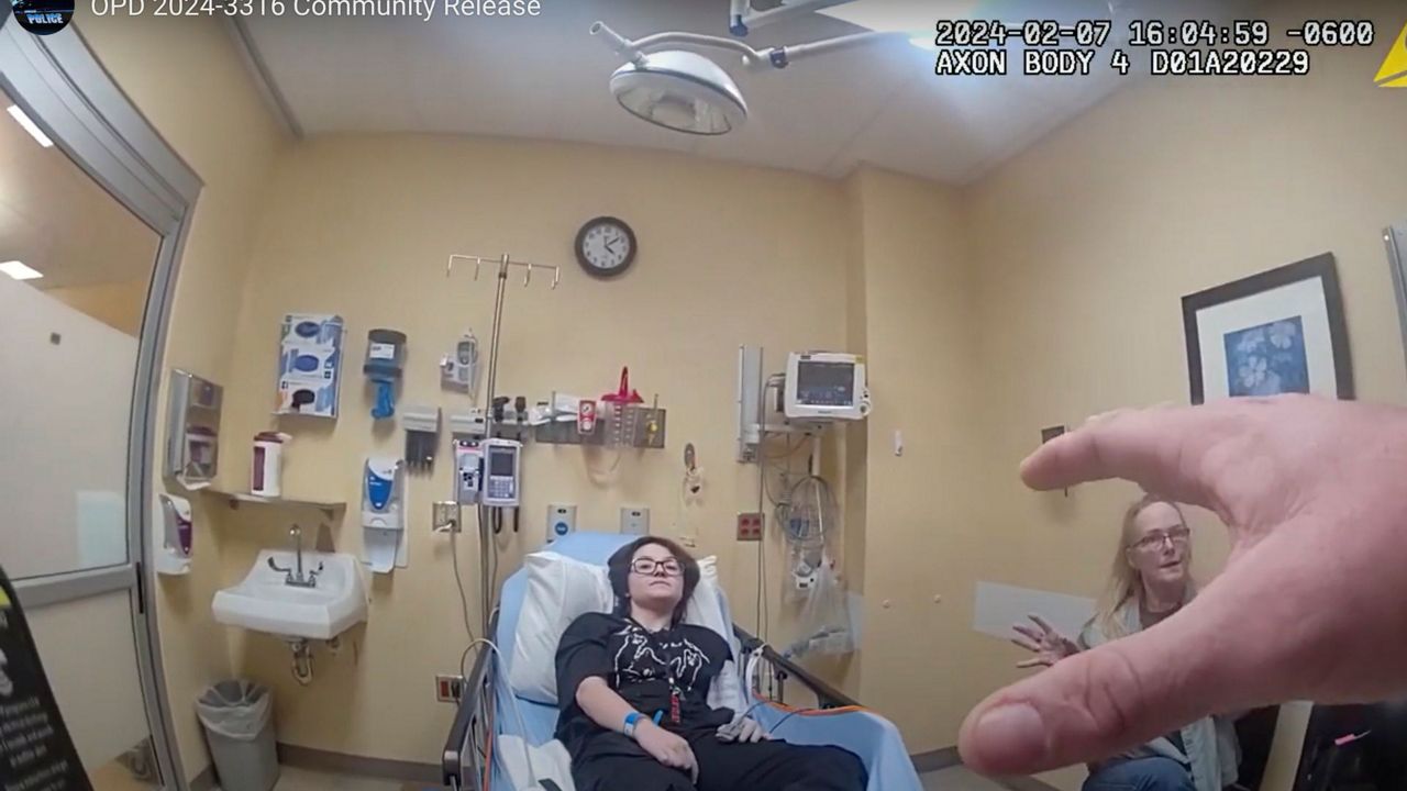 In this frame grab taken from body camera video provided by the Owasso, Okla., Police Department, an officer, hand at right, speaks to 16-year-old Nex Benedict, left, and their mother, Sue Benedict, at a hospital, Wednesday, Feb. 7, 2024. (Owasso Police Department via AP)