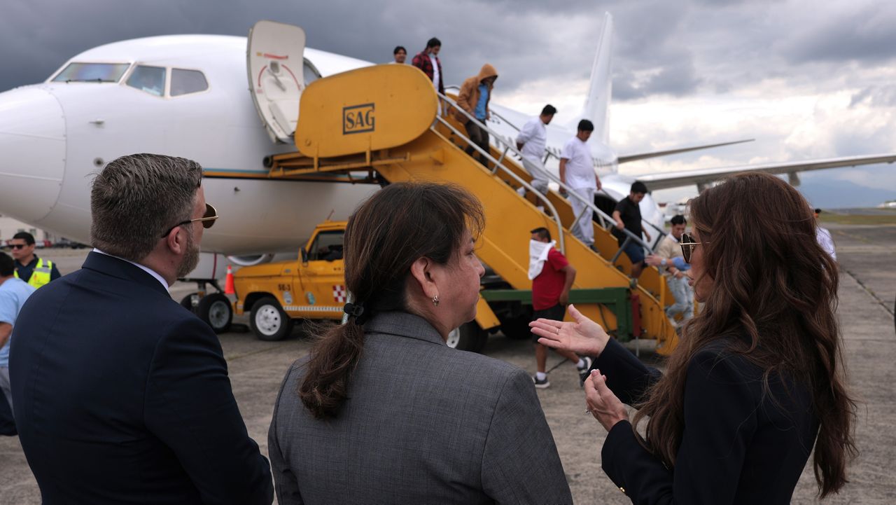 U.S. Homeland Security Secretary Kristi Noem, right, talks to ERO Regional Attaché Guadalupe "Lupita" Serna and U.S. Ambassador to Guatemala Tobin Bradley as they watch people deported from the United States disembark a repatriation flight, at La Aurora International Airport in Guatemala City, Thursday, June 26, 2025. (Anna Moneymaker/Pool Photo via AP)