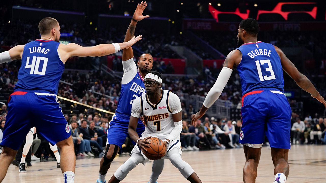 Denver Nuggets guard Reggie Jackson (7) is defended by Los Angeles Clippers center Ivica Zubac (40), guard Norman Powell, top center, and forward Paul George (13) during the first half of an NBA basketball game, Monday, Nov. 27, 2023, in Los Angeles. (AP Photo/Ryan Sun)