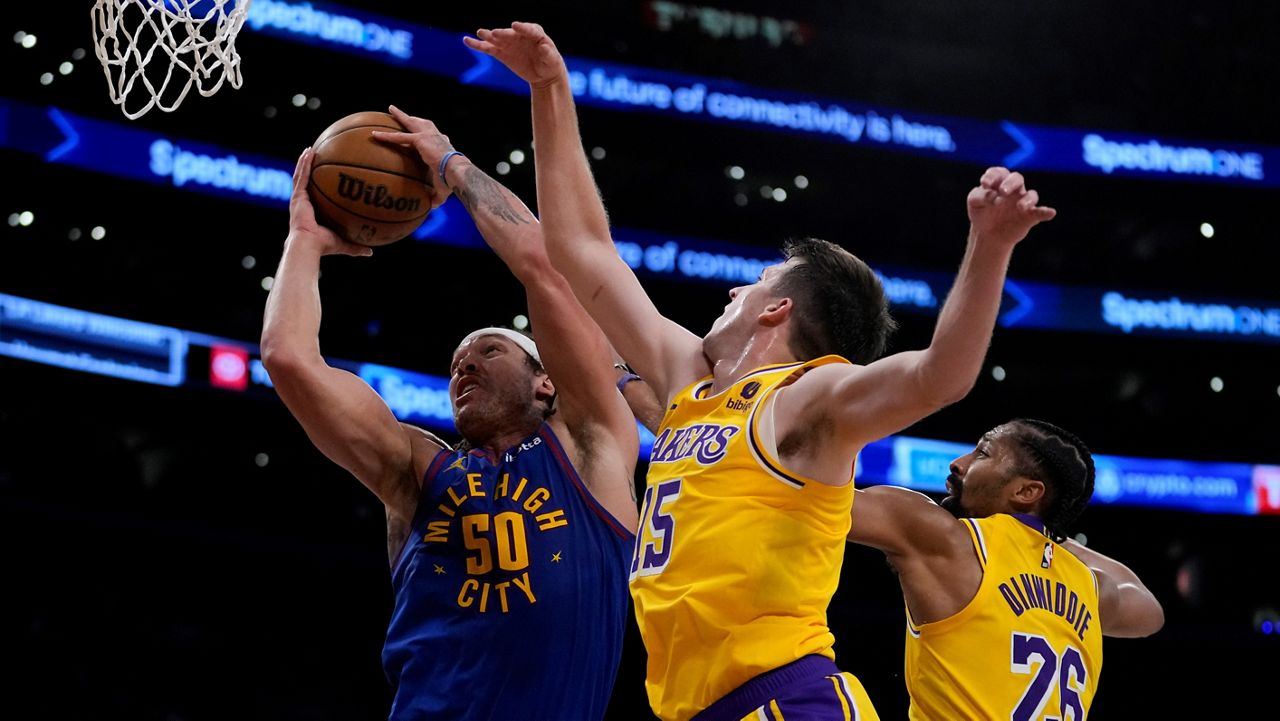 Denver Nuggets forward Aaron Gordon (50) shoots against Los Angeles Lakers guard Austin Reaves (15) during the first half of Game 3 of an NBA basketball first-round playoff series in Los Angeles, Thursday, April 25, 2024. (AP Photo/Ashley Landis)