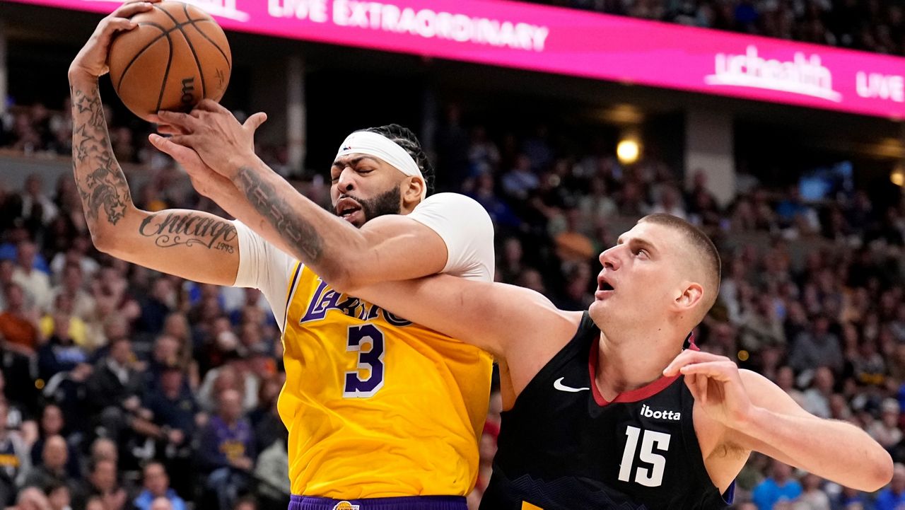Los Angeles Lakers forward Anthony Davis (3) and Denver Nuggets center Nikola Jokic (15) battle for the ball during the first half in Game 2 of an NBA basketball first-round playoff series Monday, April 22, 2024, in Denver. (AP Photo/Jack Dempsey)