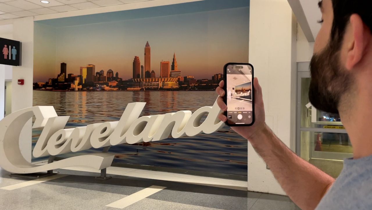 A traveler takes a photo on his way out of Cleveland Hopkins International Airport. 