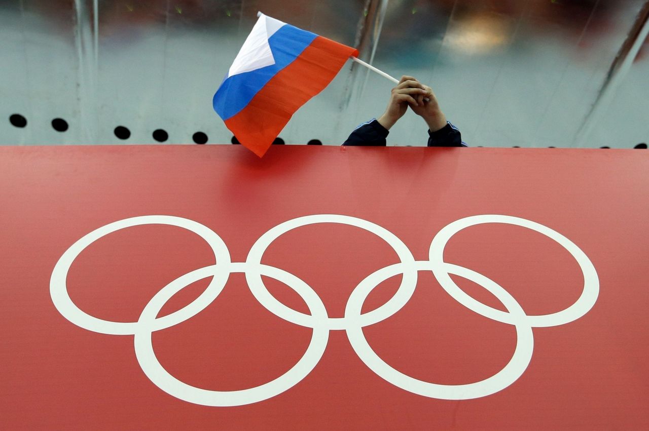 Russian gymnast stands on the podium with symbol supporting