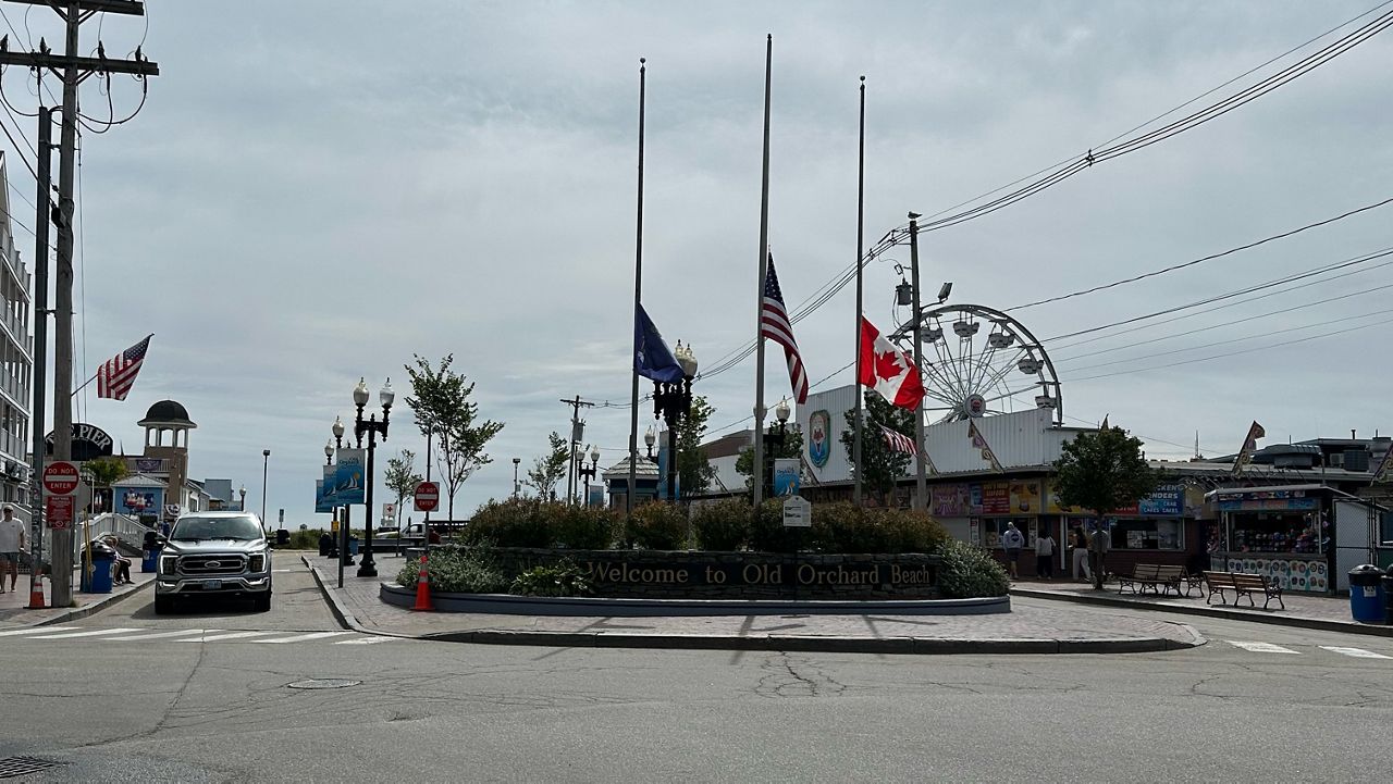 The Canadian flag flies alongside the American flag at the entrance to the walking area on Old Orchard Street in Old Orchard Beach on Tuesday. (Spectrum News/Sean Murphy)