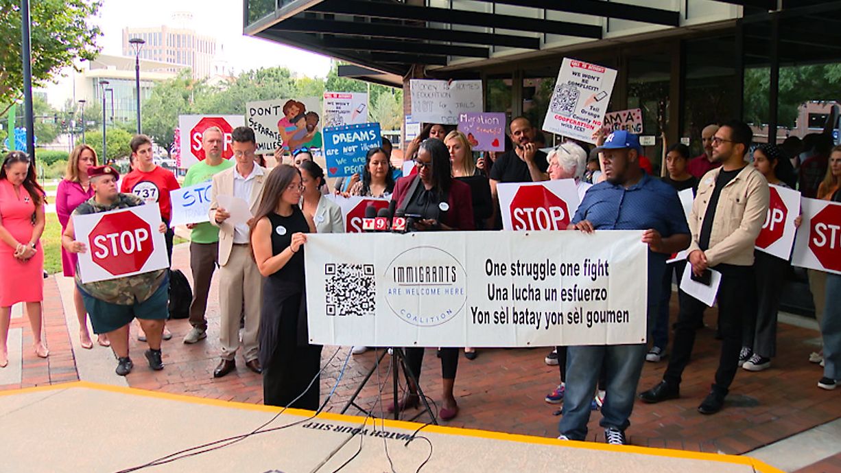 Dozens of people gather for a rally in front of the Orange County Administrative Center Tuesday to ask the Board of Commissioners to reconsider the county's agreements with ICE. (Spectrum News/Brandon Spencer)