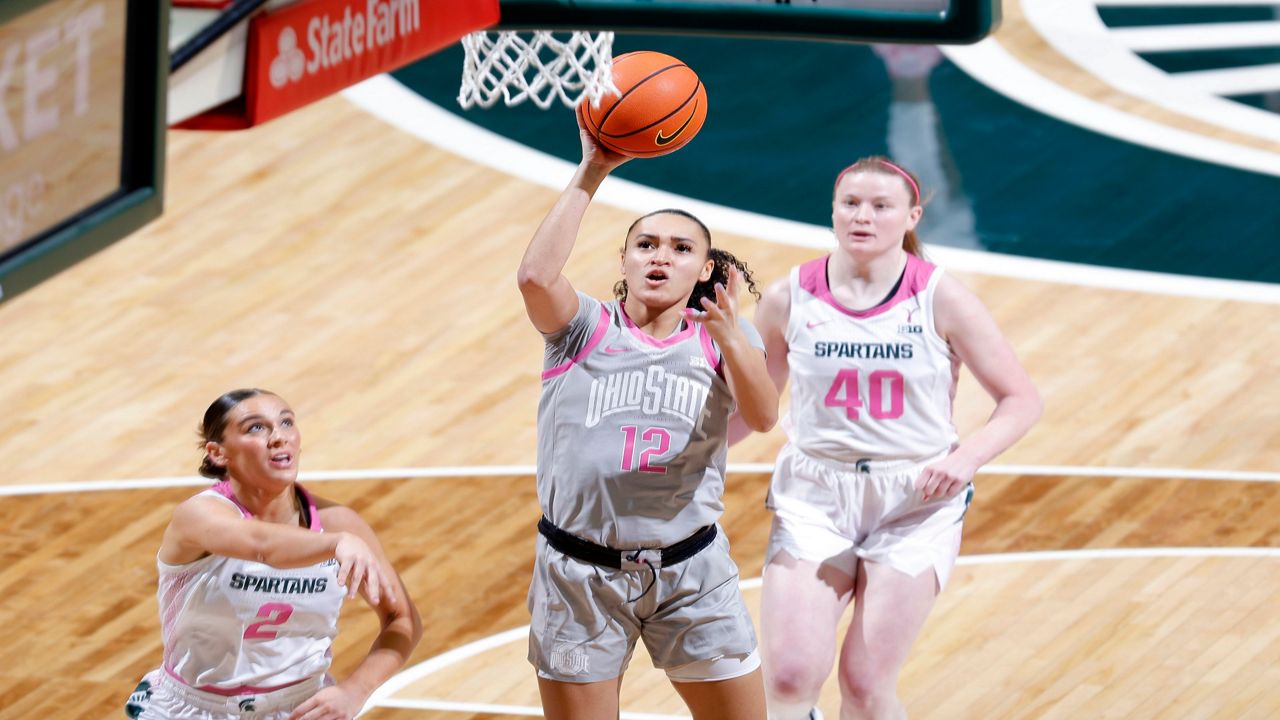 Ohio State guard Celeste Taylor (12) shoots against Michigan State guard Abbey Kimball (2 and Michigan State guard Julia Ayrault (40) during the first half of an NCAA college basketball game, Sunday, Feb. 11, 2024, in East Lansing, Mich. (AP Photo/Al Goldis)