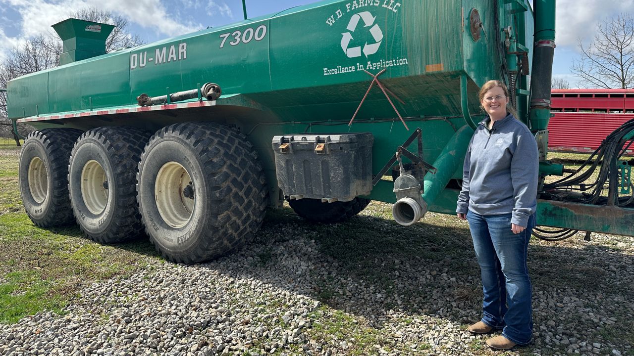 Megan Dresbach, the vice president of W.D. Farms LLC, standing next to her equipment manufactured in Canada. 