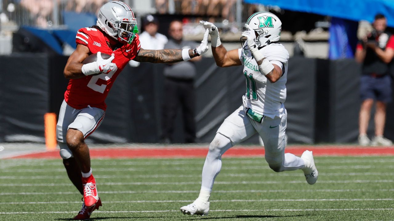 Ohio State receiver Emeka Egbuka, left, tries to stiff arm Marshall defensive back J.J. Roberts during the first half of an NCAA college football game Saturday, Sept. 21, 2024, in Columbus, Ohio.