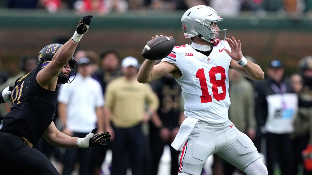 Ohio State quarterback Will Howard passes under pressure from Northwestern defensive lineman Aidan Hubbard during the first half of an NCAA college football game at Wrigley Field on Saturday, Nov. 16, 2024, in Chicago. 