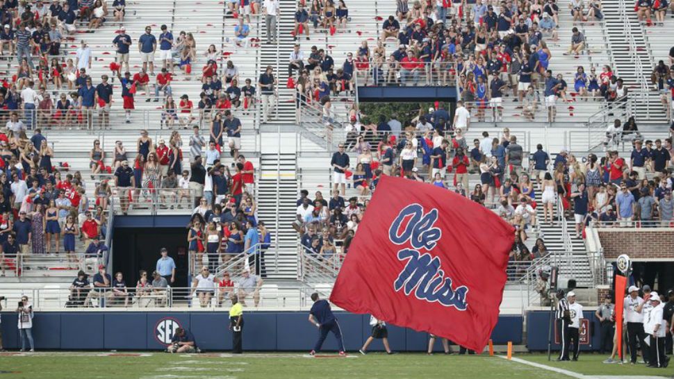 In this Sept. 8, 2018, photo, a Mississippi cheerleader waves the school flag in front of a number of empty end zone seats during their home opener against Southern Illinois, in Oxford, Miss. The SEC saw a drop of more than 2,400 fans per game last season, which was the biggest decline of any Power Five conference. (AP Photo/Rogelio V. Solis)