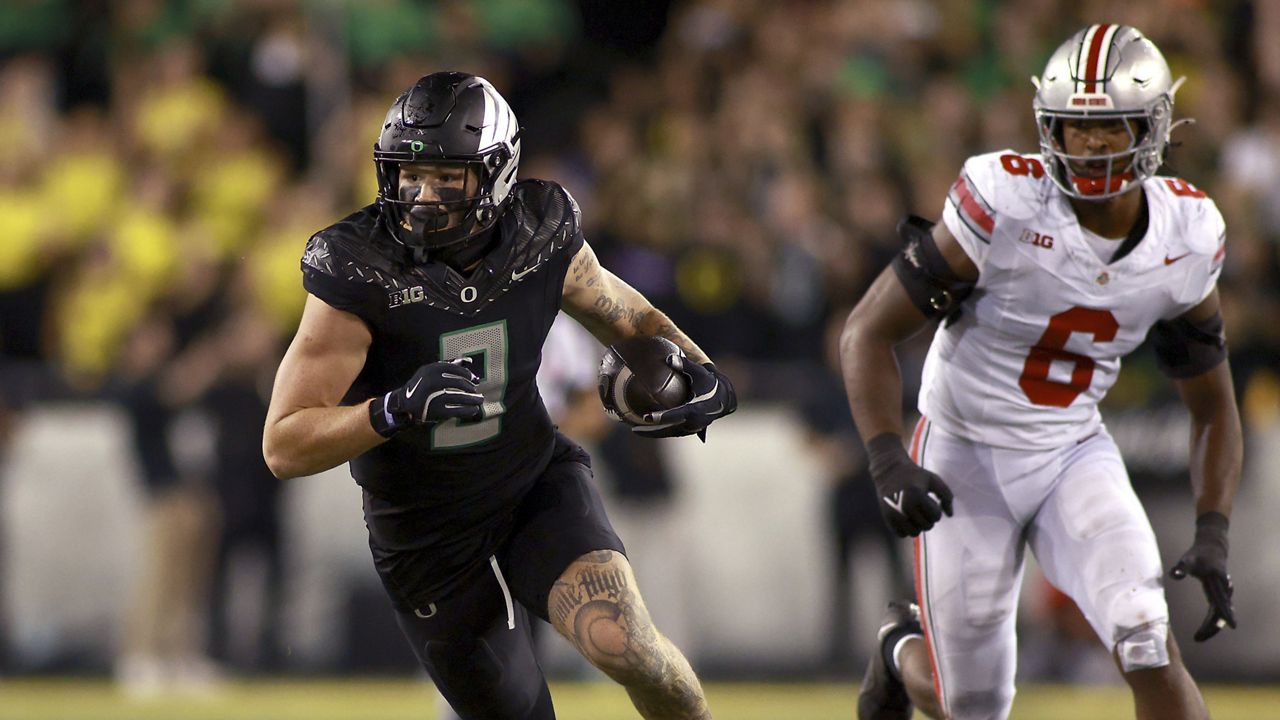 Oregon running back Jordan James (20) runs with the ball and is chased by Michigan linebacker Ernest Hausmann (15) and defensive lineman Rayshaun Benny (26) during the second half of an NCAA college football game, Saturday, Nov. 2, 2024, in Ann Arbor, Mich. Oregon defeated Michigan 38-17. (AP Photo/Jose Juarez)