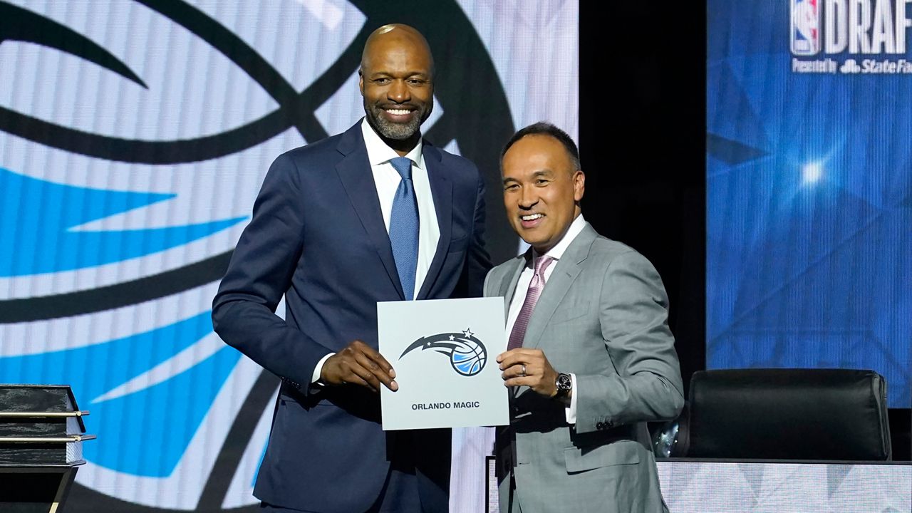 Orlando Magic head coach Jamahl Mosley, left, stands with NBA deputy commissioner Mark Tatum after Tatum announced that the Magic have won the first pick in the 2022 NBA Draft during the 2022 NBA basketball Draft Lottery Tuesday, May 17, 2022, in Chicago. (AP Photo/Charles Rex Arbogast)