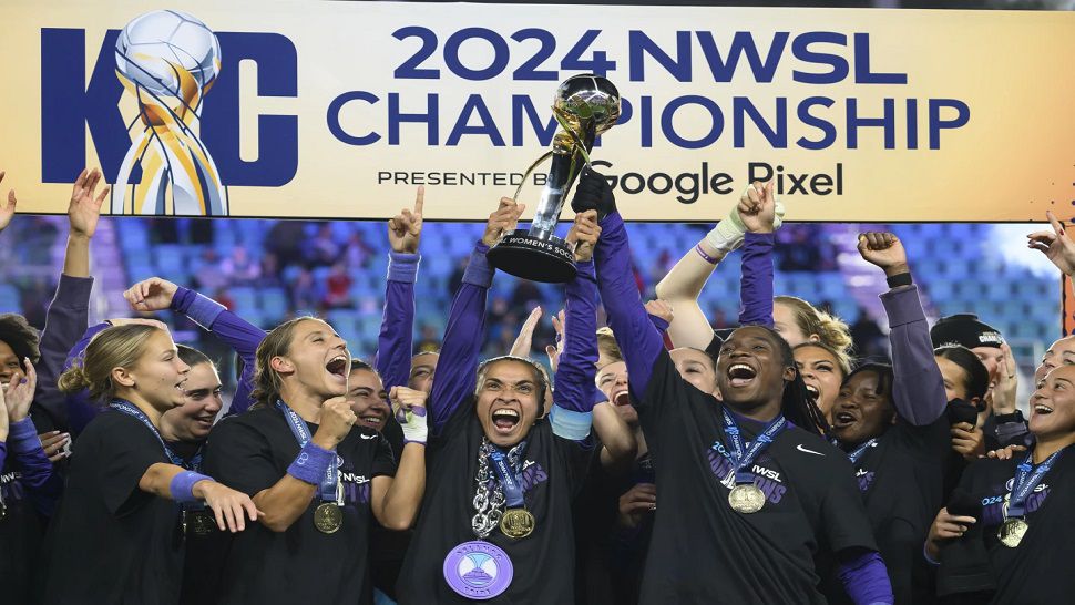 Orlando Pride forwards Marta and Barbra Banda lift the NWSL championship trophy together after defeating the Washington Spirit on Saturday night.