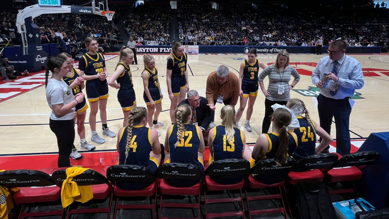 Ottawa-Glandorf High School girls basketball head coach Troy Yant leads the Lady Titans in a timeout huddle during the OHSAA Girls State Tournament final at UD Arena on Saturday.