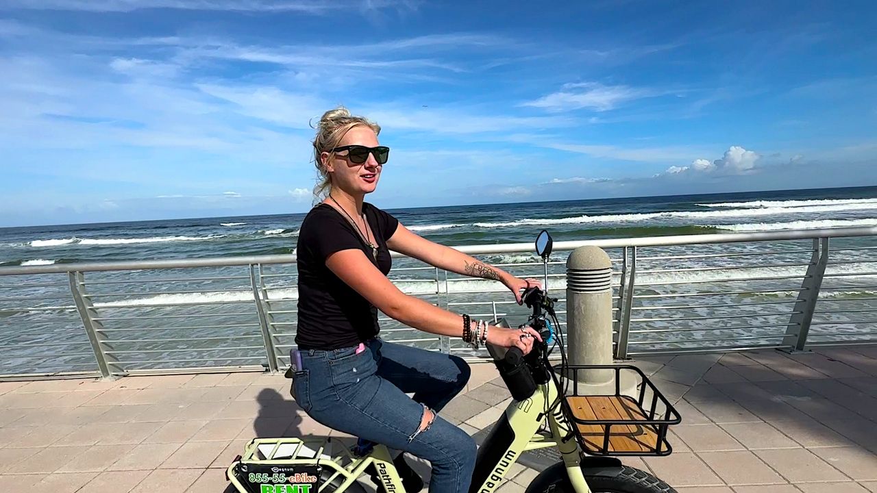 E-bike rider Peyton Rick cruises the boardwalk of Daytona Beach while sightseeing. (Spectrum News/Randy Rauch)