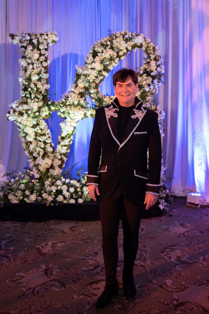 Pictured is Kemble standing in fa 12-foot-tall ‘Love’ sculpture made of white roses for the Hallam/Sanders wedding he produced on April 24, 2021. (Credit: Danny Campbell Photography)