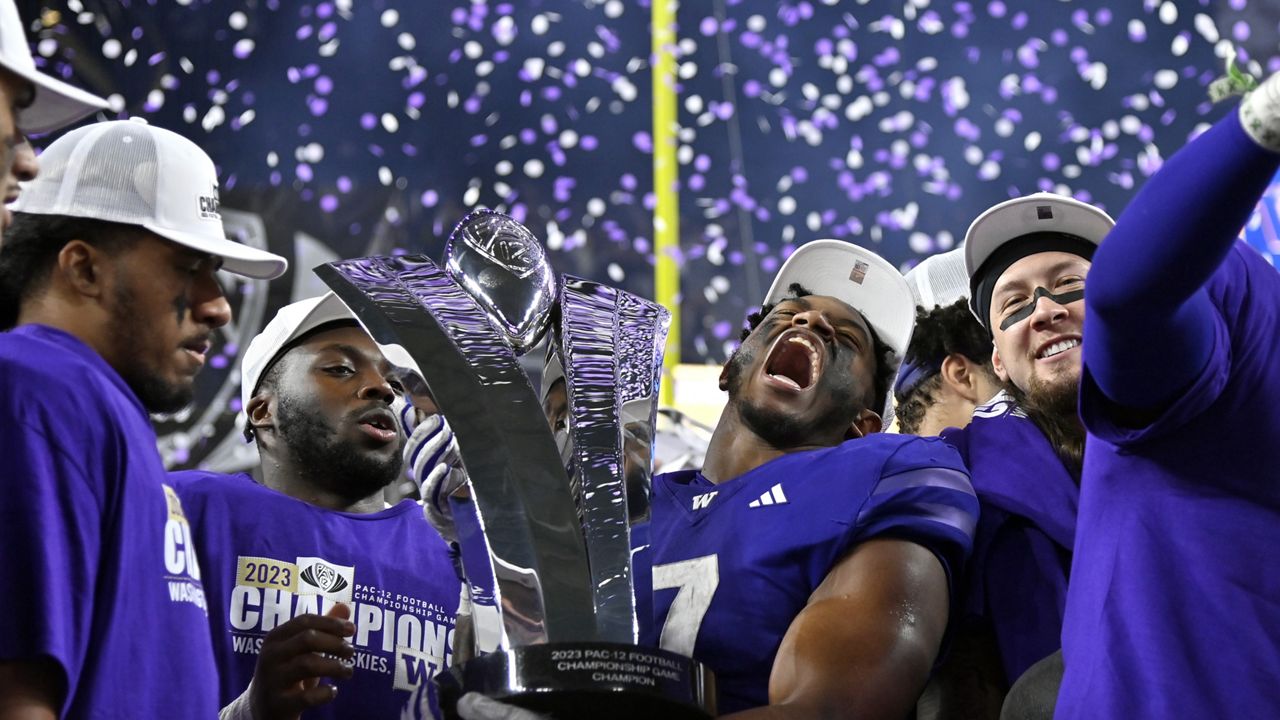 Washington running back Dillon Johnson holds the trophy after Washington defeated Oregon in the Pac-12 championship NCAA college football game Friday, Dec. 1, 2023, in Las Vegas. (AP Photo/David Becker)