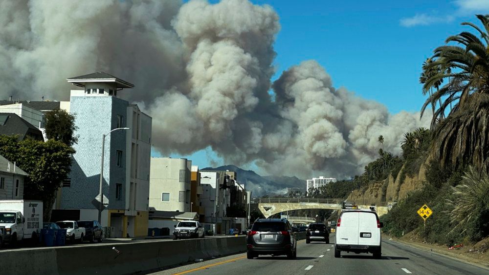 Heavy smoke from a brush fire in the Pacific Palisades rises On Jan. 7, 2025, over the Pacific Coast Highway in Santa Monica, Calif. (AP Photo/Eugene Garcia)