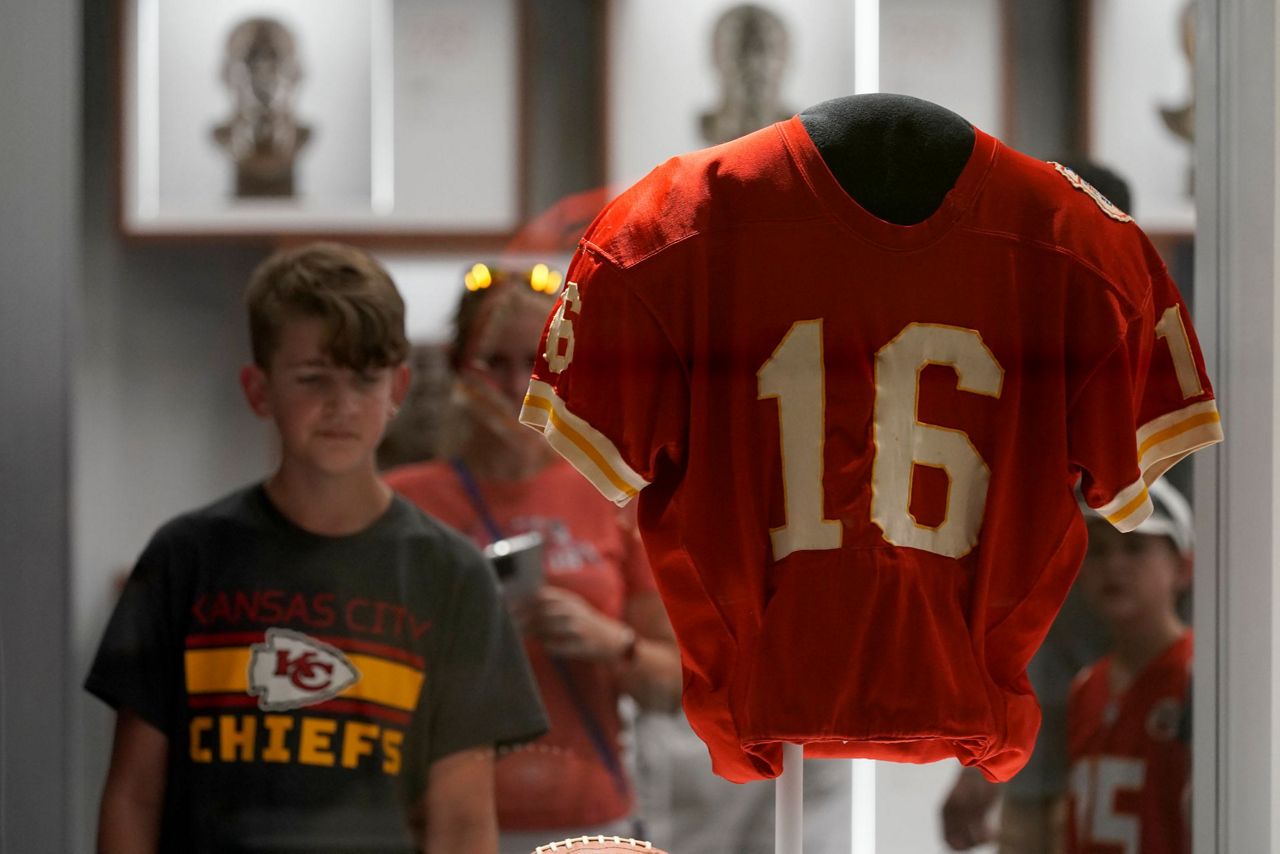 Fans have their photos made while standing next to the jersey of former  Kansas City Chiefs quarterback Len Dawson before the start of an NFL  preseason football game Thursday, Aug. 25, 2022