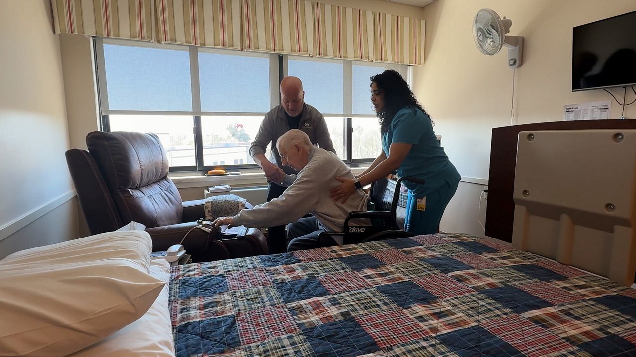CNAs, Yomaira Cruz and Dan Lyman, assist a resident at the Wesley Health Care Center.