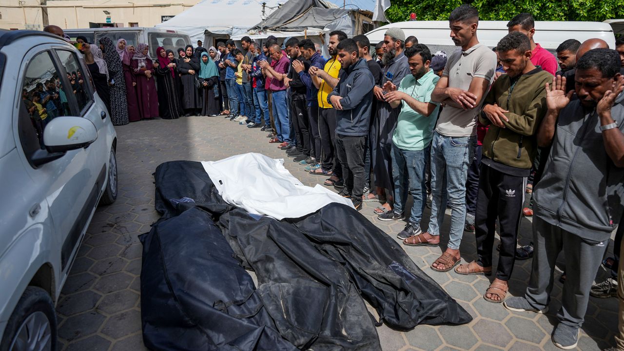 Mourners pray over the bodies of Palestinians who were killed in an Israeli airstrike in Nuseirat, at the Al Aqsa hospital in Deir al Balah, Gaza Strip, Saturday, April 27, 2024. (AP Photo/Abdel Kareem Hana)