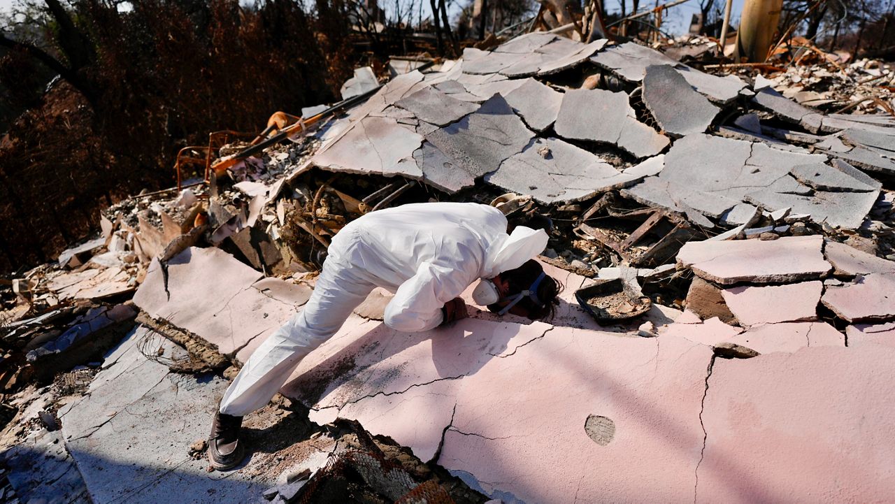 John Borbone searches through his fire-ravaged property after the Palisades Fire in the Pacific Palisades neighborhood of Los Angeles, Tuesday, Jan. 28, 2025. (AP Photo/Jae C. Hong)