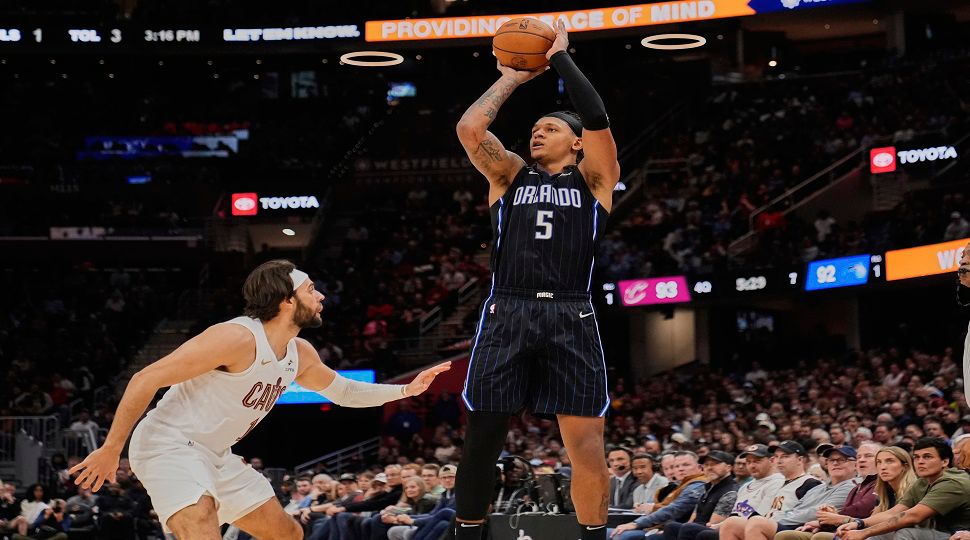 Orlando Magic forward Paolo Banchero (5) shoots over Cleveland Cavaliers guard Max Strus, left, in the second half of an NBA basketball game Sunday, March 16, 2025, in Cleveland. (AP Photo/Sue Ogrocki)