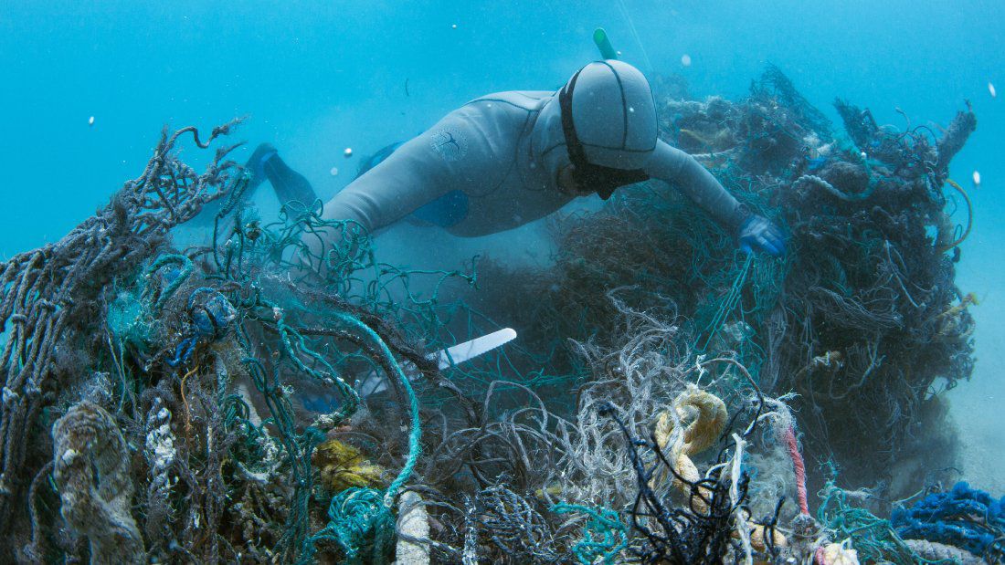 To remove ghost nets from coral reefs, divers have to locate the nets, carefully cut them so as not to damage the reef any futher, then load them onto boats by hand. (Photo courtesy of Papahanaumokuakea Marine Debris Project)