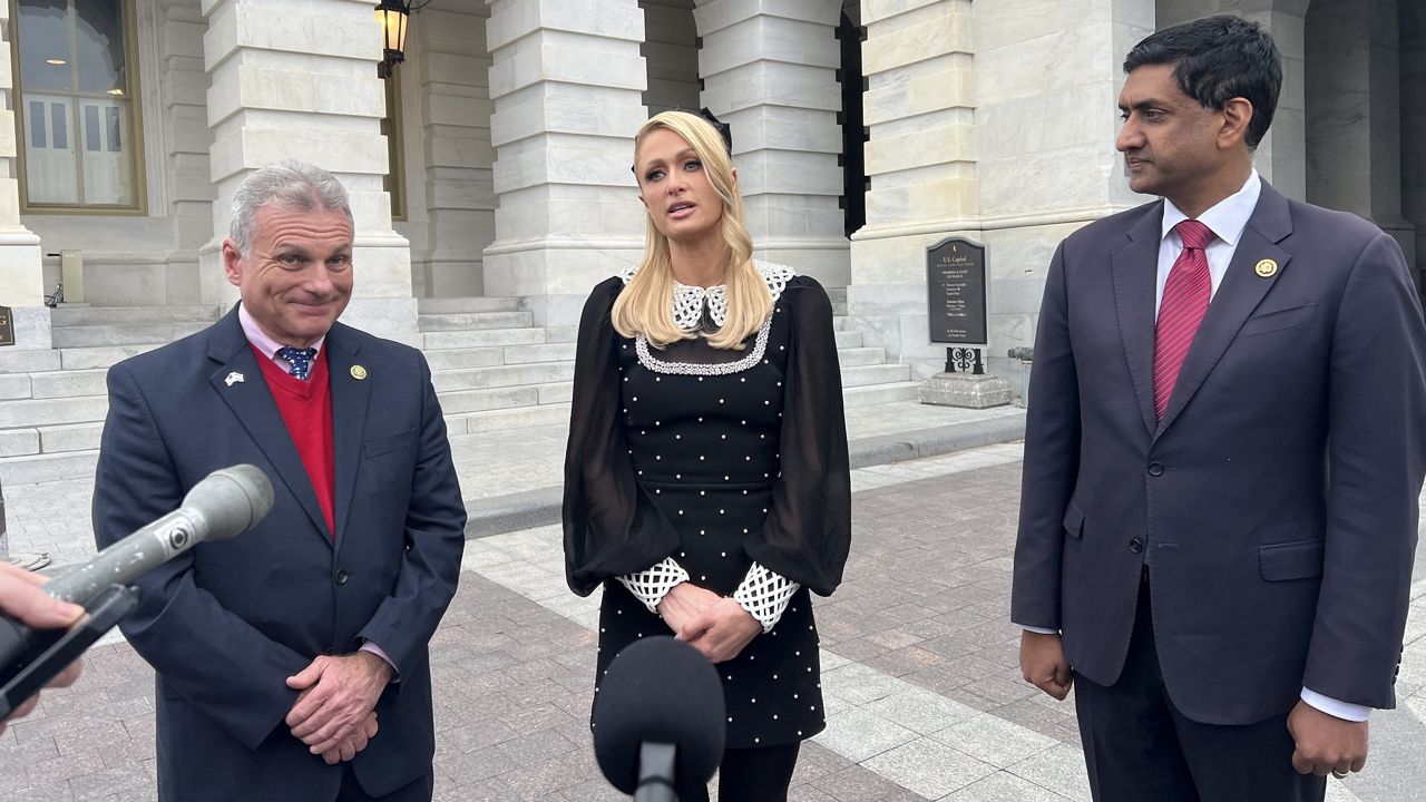 Paris Hilton, center, speaks after the House passed a bill she supported that would reform youth treatment facilities like the one she was abused at as a teenager. Reps. Ro Khanna, D-Calif., (left) and Buddy Carter, R-Ga., (right) co-sponsored the legislation. (Spectrum News/Cassie Semyon)