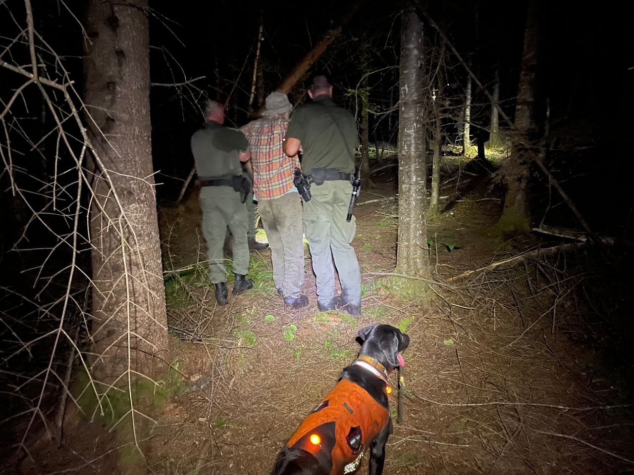 Maine game wardens help Gene Wilbur, 85, of Parkman, walk out of the woods Monday night after he was reported missing. (Maine Warden Service photo)