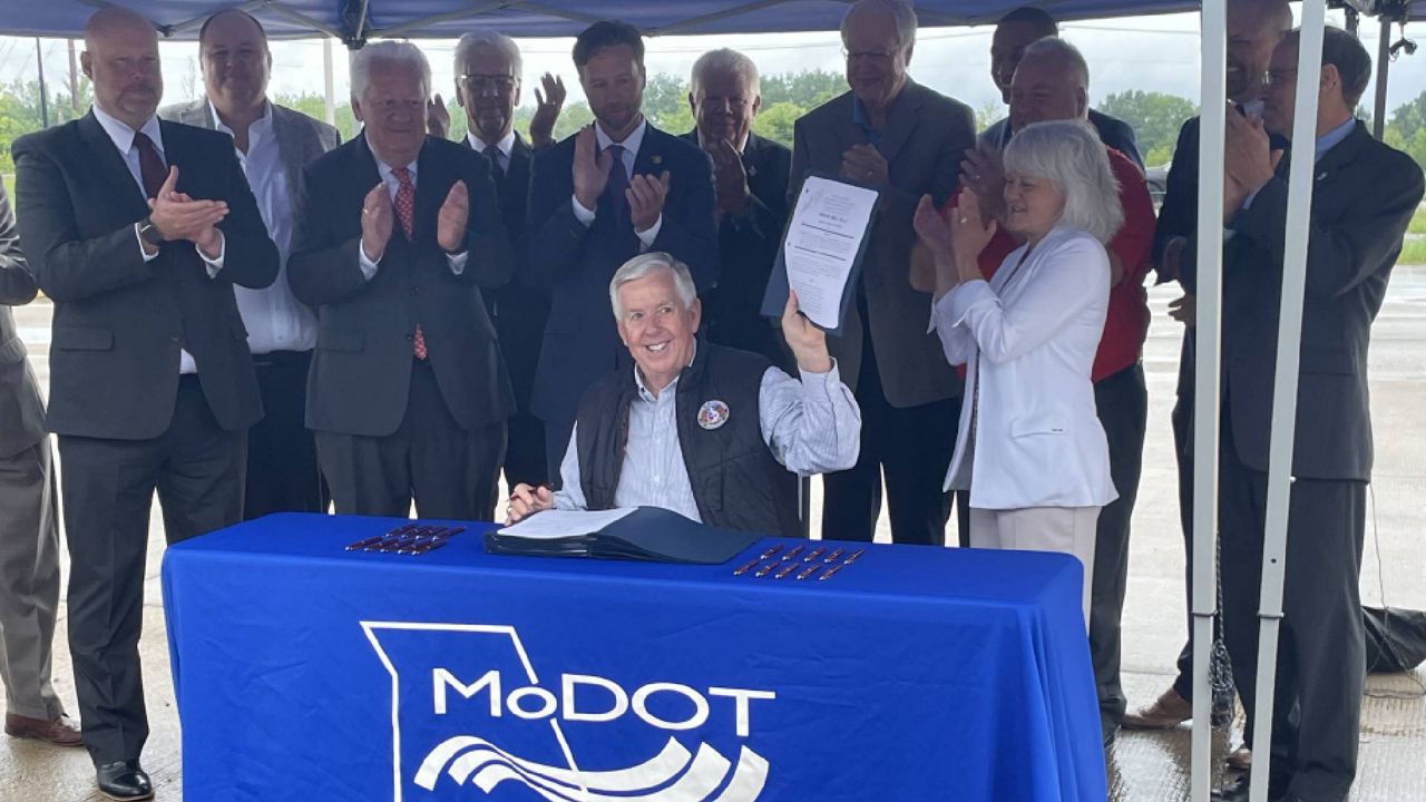 During a bill signing ceremony Monday Aug. 14 in Foristell, Mo., Gov. Mike Parson holds a signed copy of House Bill 4, which authorizes the state to spend $2.8 billion to add a third lane to Interstate 70 between Wentzville and Blue Springs. (Spectrum News/Gregg Palermo)