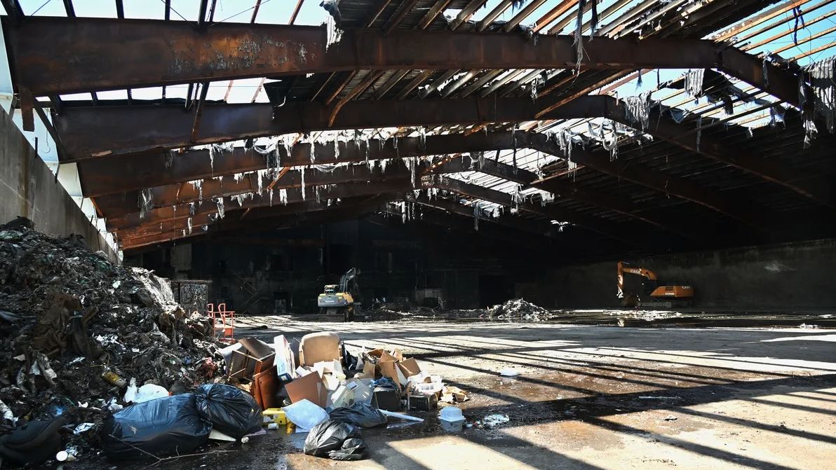 Remnants of trash and waste are piled around the burned out interior of the Eagle Point Energy Center in Orrington on April 18, 2025. A fire lasting 10-days gutted the facility last October. Credit: Julia Bayly / BDN