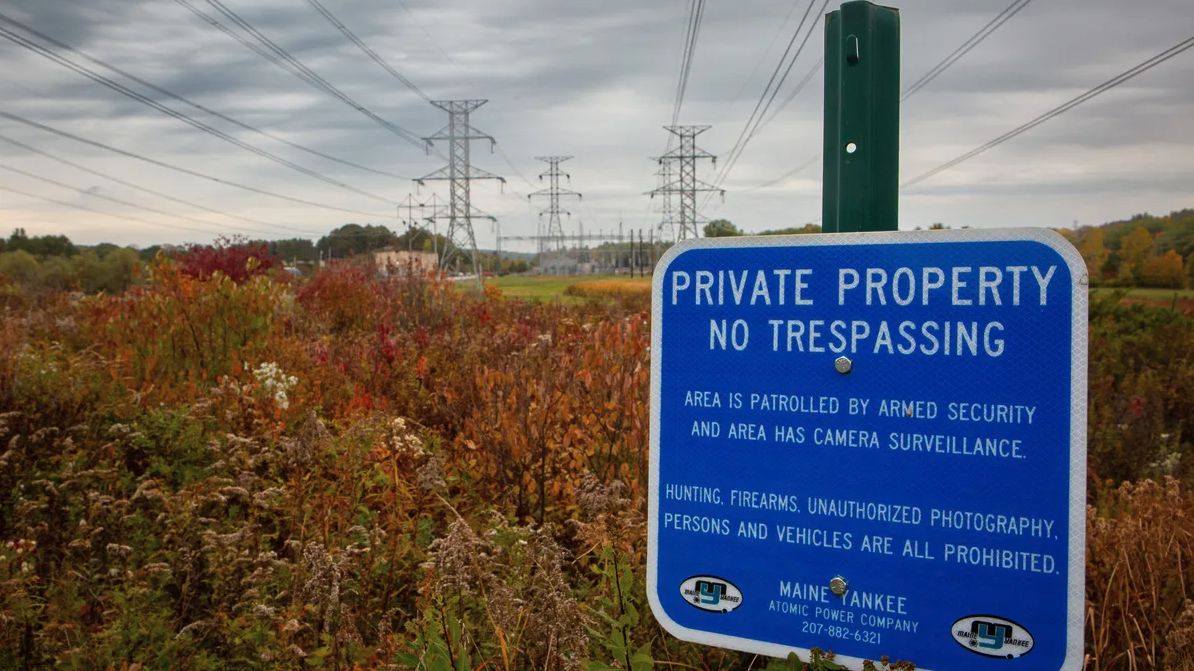 A warning sign is posted under electricity transmission lines at the site of the former Maine Yankee nuclear power plant in Wiscasset on Oct. 13. 2022. The plant generated about 119 billion kilowatt hours of electricity from 1972 through 1996. Credit: Troy R. Bennett / BDN