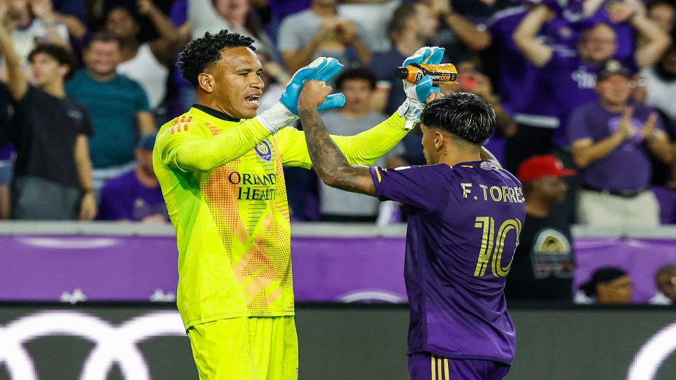 Orlando City goalkeeper Pedro Gallese congratulates teammate Facundo Torres after scoring one of the goals in the shootout against Charlotte FC on Saturday night.