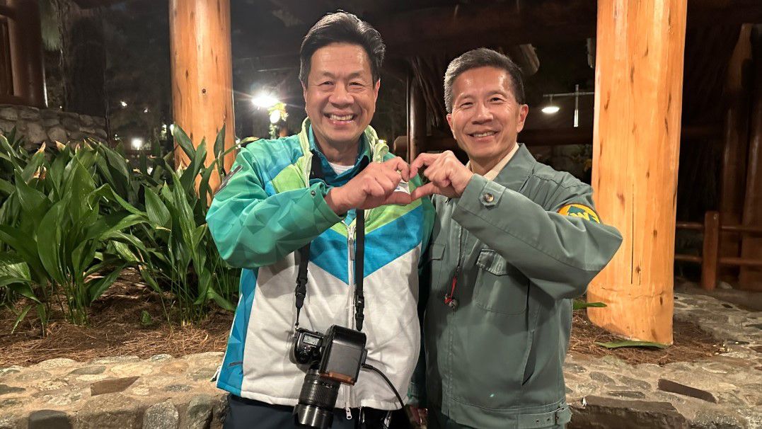Brothers Jerry and Peter Wong smile and each use a hand to create a hand heart. (Spectrum News/Jo Kwon)