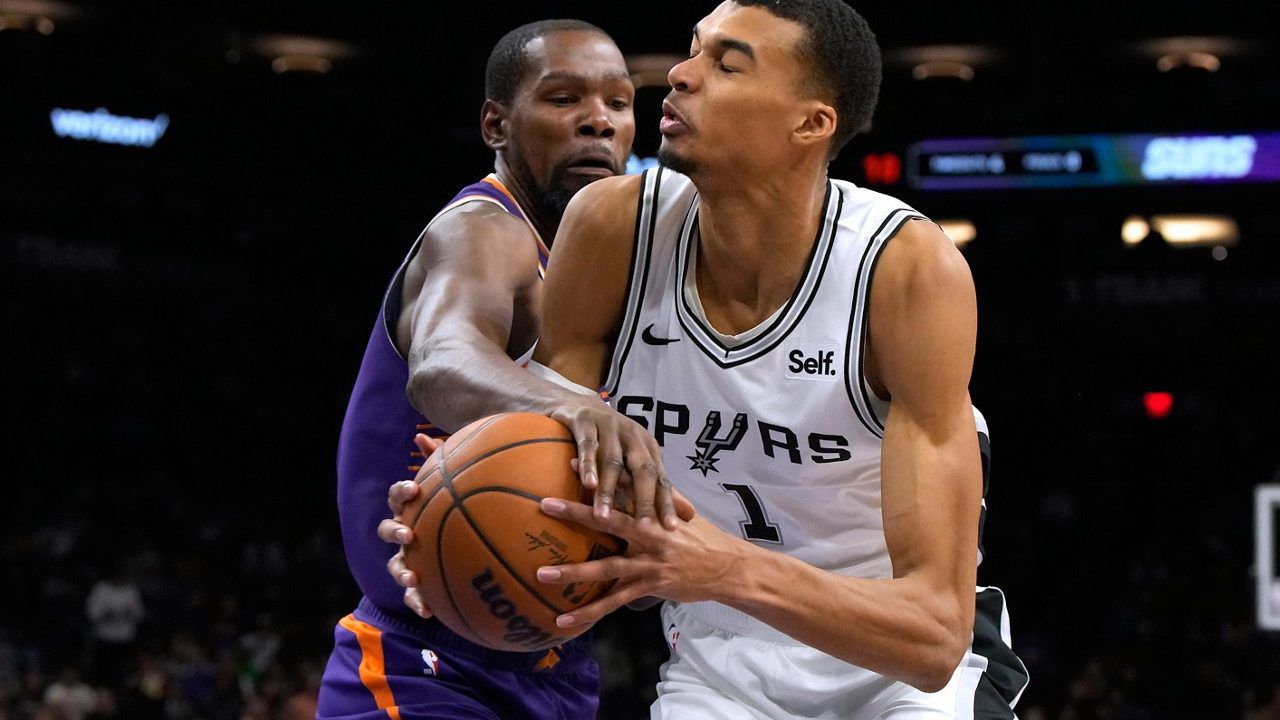 Phoenix Suns forward Kevin Durant fouls San Antonio Spurs center Victor Wembanyama (1) during the second half of an NBA basketball game Thursday, Nov 2, 2023, in Phoenix. (AP Photo/Rick Scuteri)