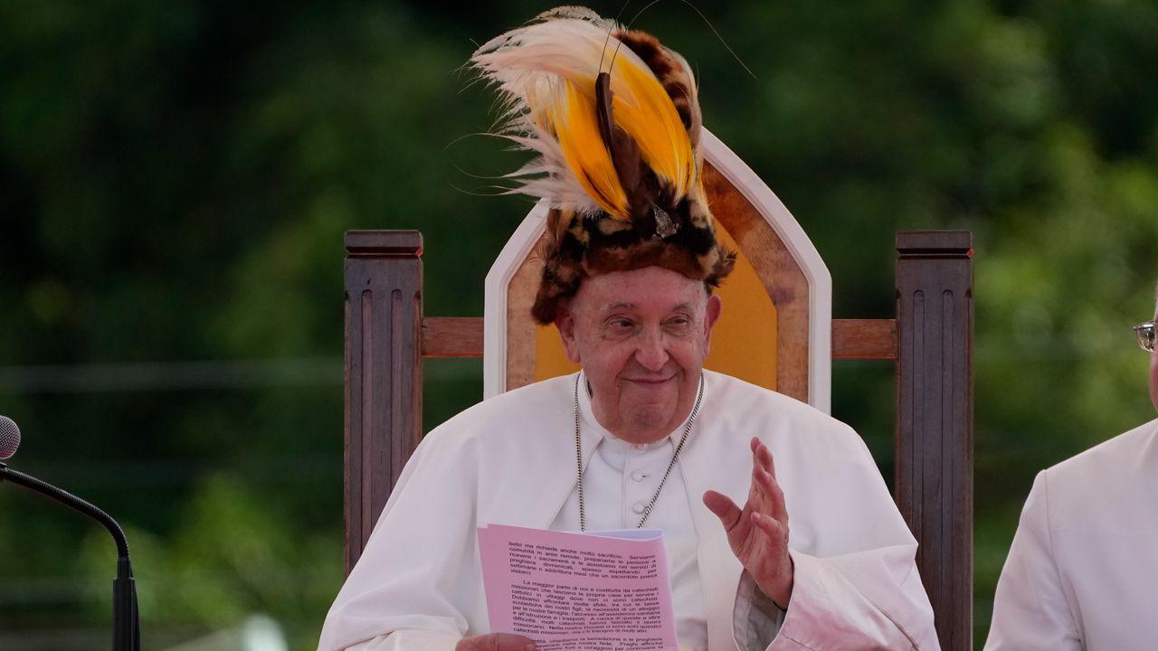 Pope Francis wears a traditional hat during a meeting with faithful in Vanimo, Papua New Guinea, Sunday, Sept. 8, 2024. . (AP Photo/Gregorio Borgia)