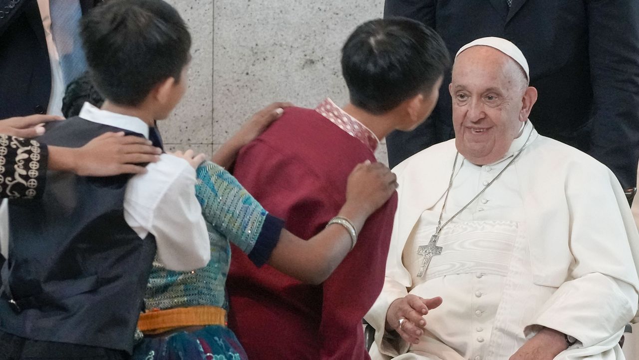 Pope Francis is welcomed by dancing children as he arrives at Singapore Changi International Airport, Wednesday, Sept. 11, 2024. Pope Francis is heading to Singapore for the final leg of his 11-day trip to Asia and Oceania. (AP Photo/Gregorio Borgia)