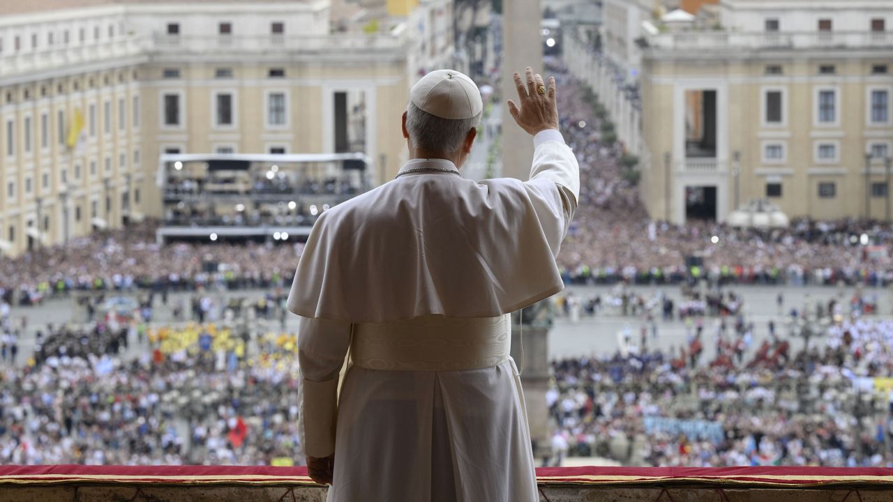 Pope Leo XIV waives from the central balcony of St. Peter's Basilica overlooking St. Peter's Square where tens of thousands of faithful gathered at noon to receive the first traditional Sunday blessing after his election on Thursday and to pray the Regina Caeli, Sunday, May 11, 2025. (Vatican Media via AP)