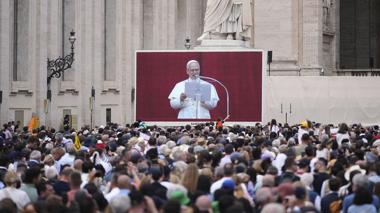 People watch Pope Leo XIV on a giant screen as he delivers his blessing from the central balcony of St. Peter's Basilica for his first Sunday blessing after his election, in St. Peter's Square at the Vatican, Sunday, May 11, 2025.(AP Photo/Andrew Medichini)