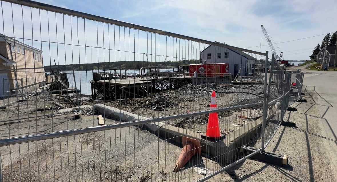 A fence surrounds the site where the Port Clyde General Store once stood following a devastating September fire. (Spectrum News/Susan Cover)