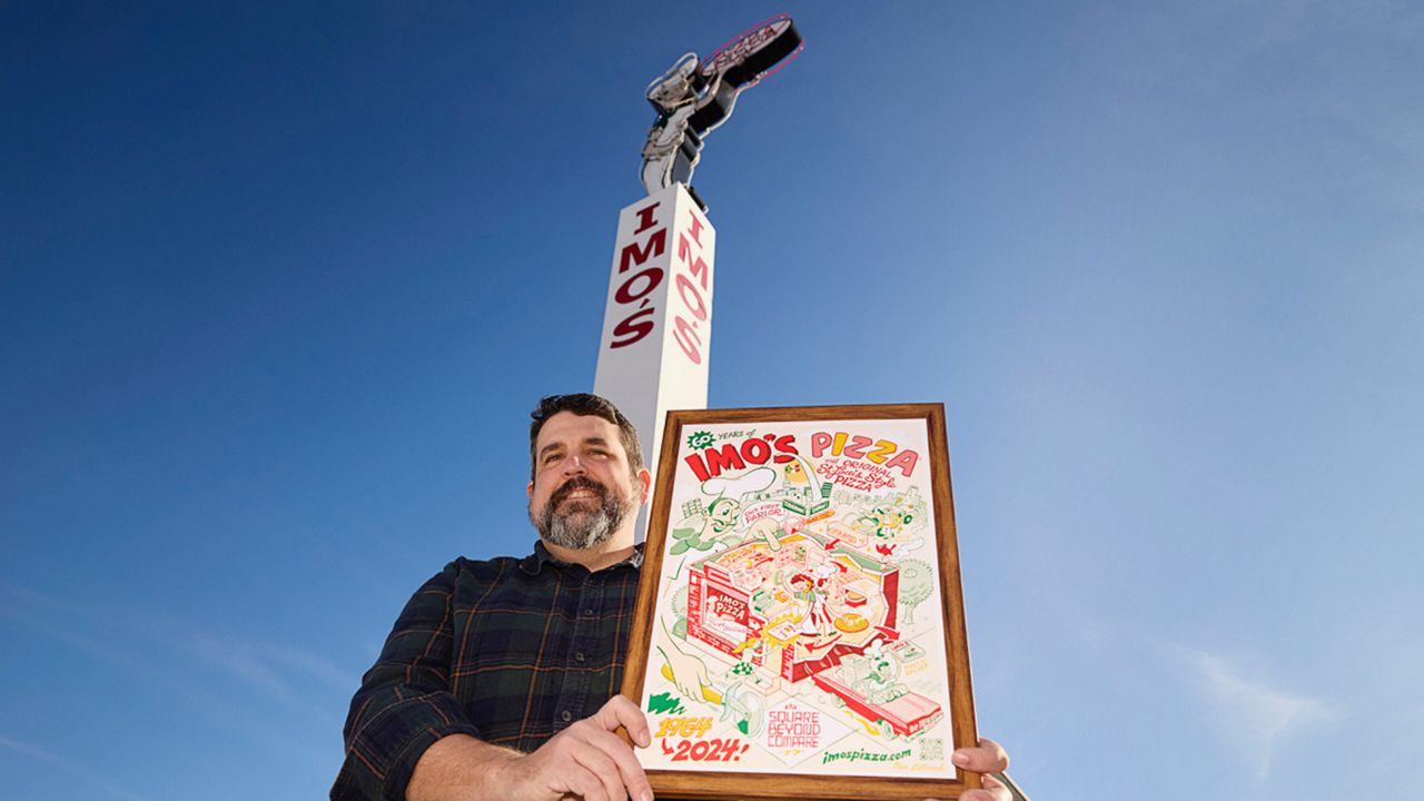 Local artist Dan Zettwoch holds the limited edition Imo's poster that he designed, which celebrates Imo's 60th anniversary. (Photo courtesy of Imo's)