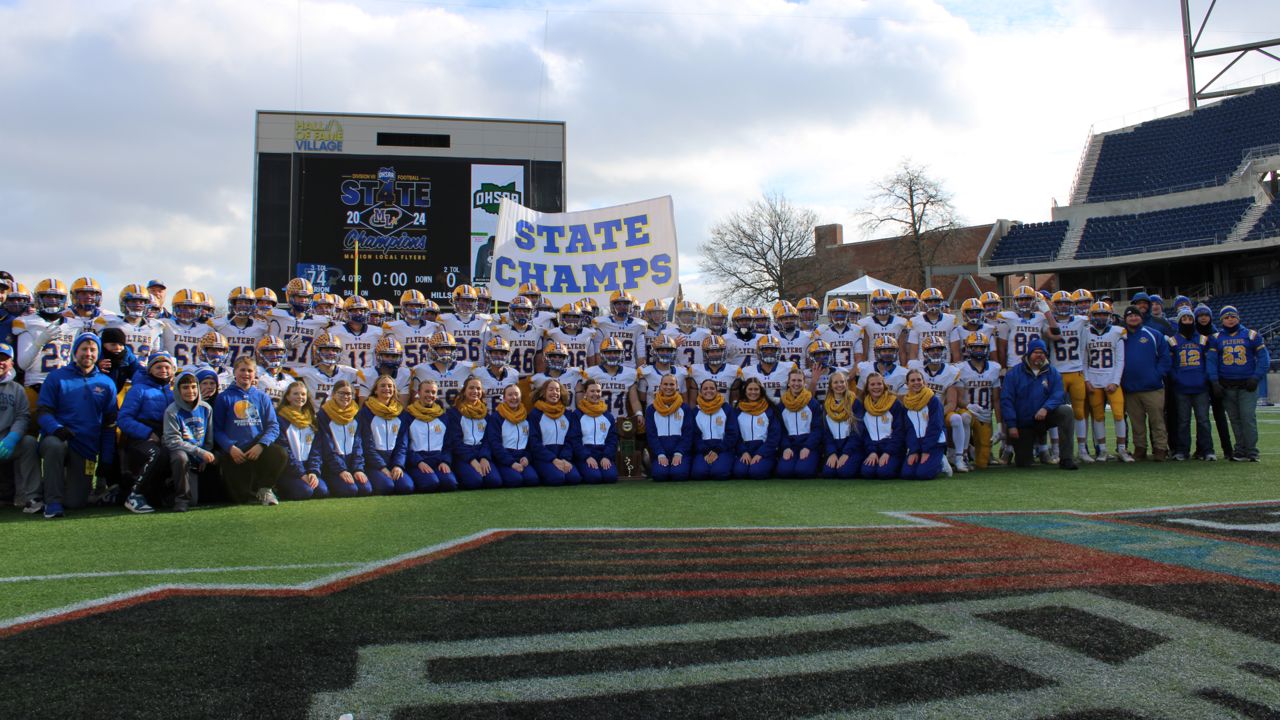 The Maria Stein Marion Local High School football team and cheerleaders stand together after the OHSAA Division VII football state championship game at Tom Benson Hall of Fame Stadium on Friday.