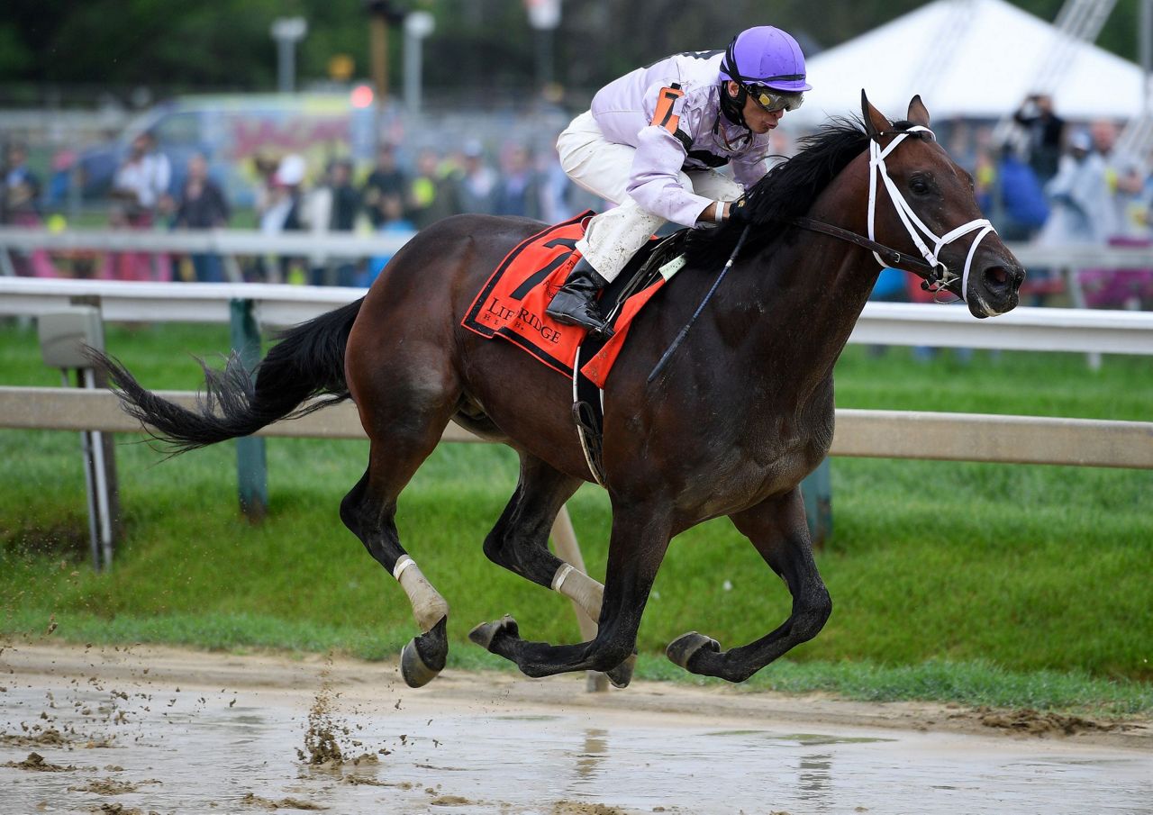 The Latest: Rain soaks fans, creates sloppy track at Pimlico